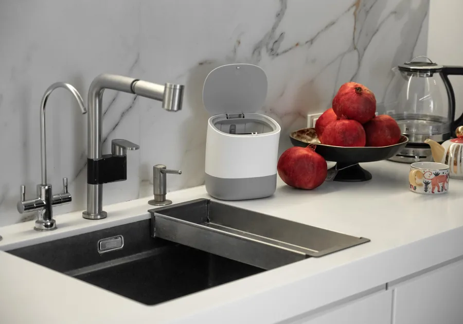 Stainless steel kitchen sink with a waste disposal unit beneath